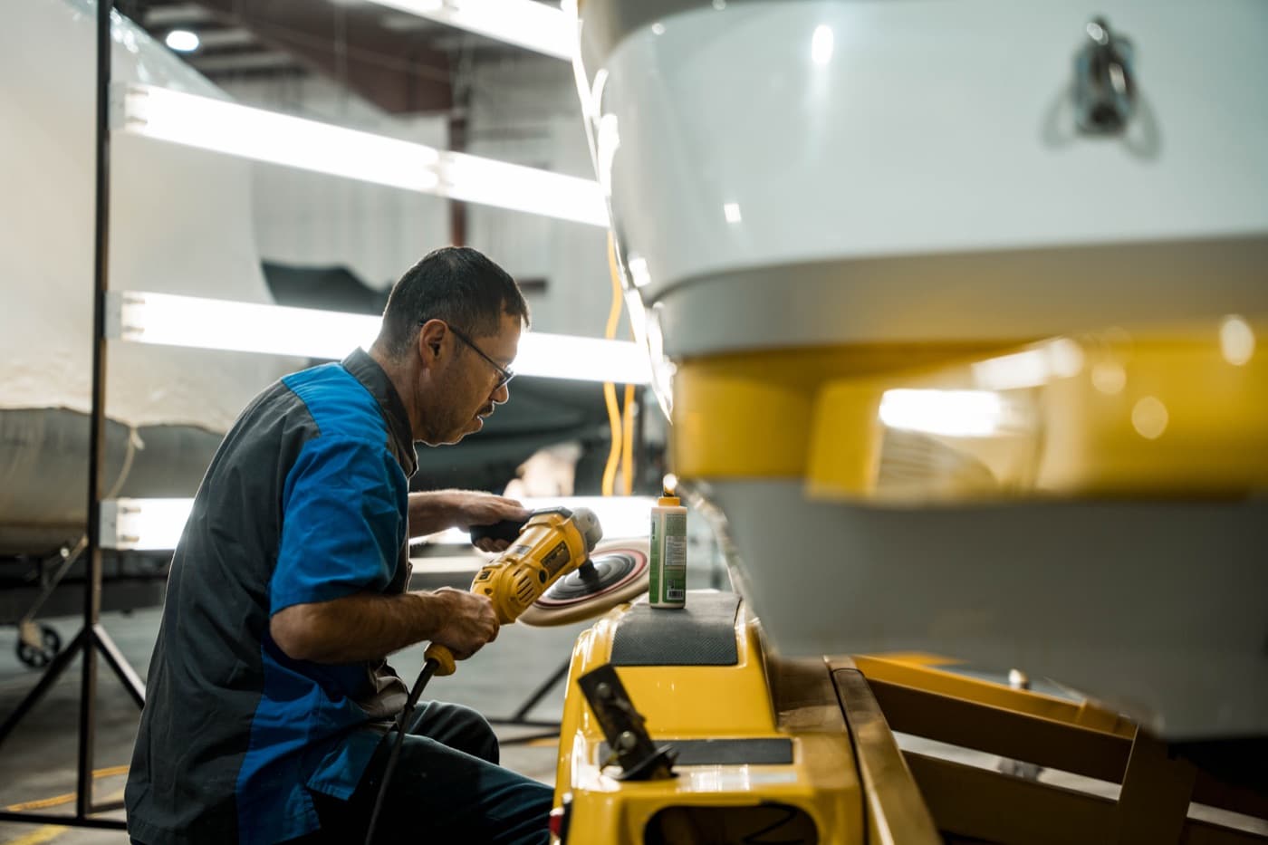 Technician buffing a repaired hull to a factory gloss